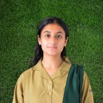 This image shows a picture of Aisha Khan, House captain of Poseidon, in her khaki, Eden College unifor, against a green turf background